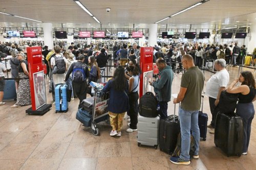 People stand in a line to check in at Brussels International Airport in Zaventem, Belgium, Saturday, Sept. 20, 2025. (AP Photo/Harry Nakos)
