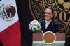 Mexican President Claudia Sheinbaum holds a soccer ball as she speaks about Mexico co-hosting the 2026 FIFA World Cup during her daily press conference at Los Pinos Cultural Complex in Mexico City, Monday, Nov. 10, 2025. (AP Photo/Marco Ugarte)