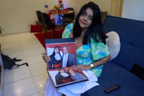 Simone Guimarães holds a photo of herself with her husband, who died from COVID at her home in Sao Goncalo, Rio de Janeiro state, Wednesday, Nov 19, 2025. (AP Photo/Silvia Izquierdo)