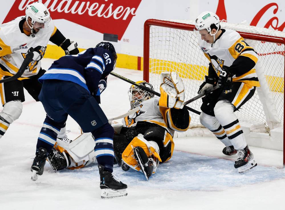 Winnipeg Jets' Morgan Barron (36) looks for the rebound off Pittsburgh Penguins goaltender Arturs Silovs (37) during second period NHL action in Winnipeg, Saturday, Nov. 1, 2025. THE CANADIAN PRESS/John Woods