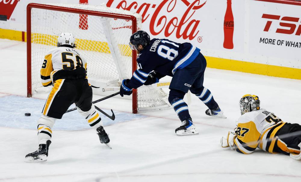 Pittsburgh Penguins goaltender Arturs Silovs (37) who was caught out of his net throws his stick at Winnipeg Jets' Kyle Connor (81) during second period NHL action in Winnipeg, Saturday, Nov. 1, 2025. Connor got a penalty shot for the infraction. THE CANADIAN PRESS/John Woods