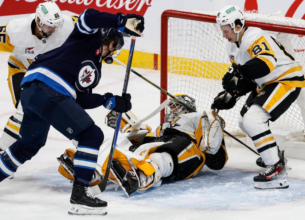 Winnipeg Jets' Morgan Barron (36) looks for the rebound off Pittsburgh Penguins goaltender Arturs Silovs (37) during second period NHL action in Winnipeg, Saturday, Nov. 1, 2025. THE CANADIAN PRESS/John Woods