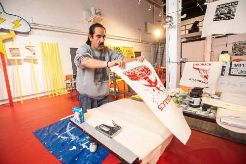 MIKAELA MACKENZIE / FREE PRESS
                                Clayton Thomas-Müller works on signs for Red Wash Stand at the Graffiti Gallery. The art
exhibition features protest banners, logos and slogans.