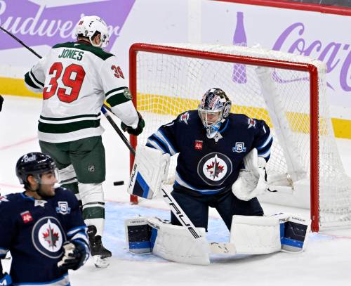 FRED GREENSLADE / THE CANADIAN PRESS
                                Winnipeg Jets’ goaltender Eric Comrie (1) makes a save on a Minnesota Wild shot as Ben Jones (39) looks for the rebound during the third period of Sunday’s game.