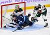 Minnesota Wild Zach Bogosian (24) dumps Winnipeg Jets’ Jonathan Toews (19) in front of his goaltender Jesper Wallstedt (30) during first period of Sunday’s game. (Fred Greenslade / The Canadian Press)