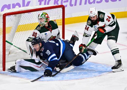 Minnesota Wild Zach Bogosian (24) dumps Winnipeg Jets’ Jonathan Toews (19) in front of his goaltender Jesper Wallstedt (30) during first period of Sunday’s game. (Fred Greenslade / The Canadian Press)