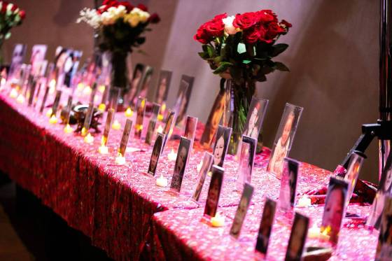 A long table holds photos of some of Manitoba’s missing and murdered Indigenous women, girls and two-spirit people at the Red Dress Alert report release event on Tuesday. (Mikaela Mackenzie / Free Press)