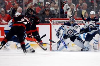 Karl DeBlaker / The Associated Press
                                Carolina’s Seth Jarvis opens the scoring by putting his first of three goals past Jets goalie Thomas Milic.