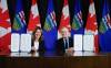 Prime Minister Mark Carney, right, signs an MOU with Alberta Premier Danielle Smith in Calgary, on Nov. 27. (Jeff McIntosh / The Canadian Press)