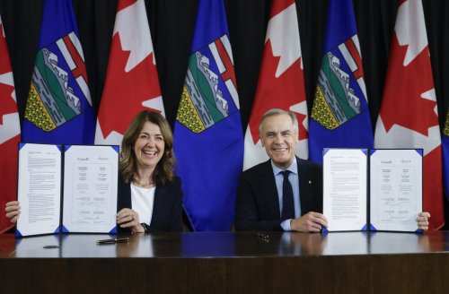 Prime Minister Mark Carney, right, signs an MOU with Alberta Premier Danielle Smith in Calgary, Alta., Thursday, Nov. 27, 2025. THE CANADIAN PRESS/Jeff McIntosh