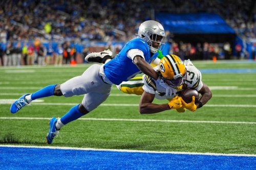 Green Bay Packers wide receiver Dontayvion Wicks (13) dives in for a touchdown under Detroit Lions cornerback Terrion Arnold (6) during the second half an NFL football game in Detroit, Thursday, Nov. 27, 2025. (AP Photo/Ryan Sun)