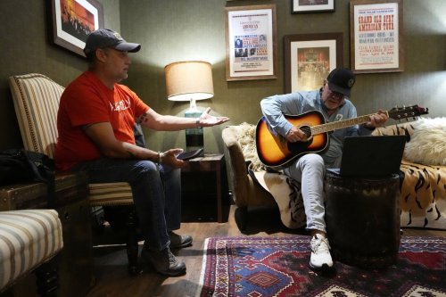 Army veteran Clay Jensen, left, talks about events in his military career as songwriter Brian White, right, puts them into lyrics as they work in a dressing room in the Grand Ole Opry House as part of the CreatiVets program on Tuesday, Sept. 8, 2025, in Nashville, Tenn. (AP Photo/Mark Humphrey)