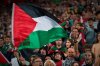 Fans wave Palestinian flags during a friendly match between a selection of Palestinian players and a group of Spanish players from the Basque Country, held to protest Israel's military actions in Gaza, in Bilbao, Spain, Saturday, Nov. 15, 2025. (AP Photo/Miguel Oses)
