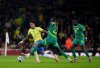 Brazil's Eder Militao, left, and Senegal's Pape Gueye battle for the ball during an international soccer match between Brazil and Senegal at the Emirates Stadium, London, Saturday, Nov. 15, 2025. (John Walton/PA via AP)