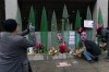 People take pictures of a makeshift memorial of flags, flowers and other items outside of Farragut West Station, in Washington, Sunday, Nov. 30, 2025, near the site where two National Guard members were shot. (AP Photo/Jose Luis Magana)