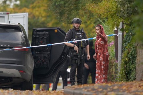 FILE - An armed police officer speaks to member of the public near the scene of a stabbing incident at Heaton Park Hebrew Congregation synagogue, in Crumpsall, Manchester, England, on Oct. 2, 2025. (AP Photo/Ian Hodgson, File)