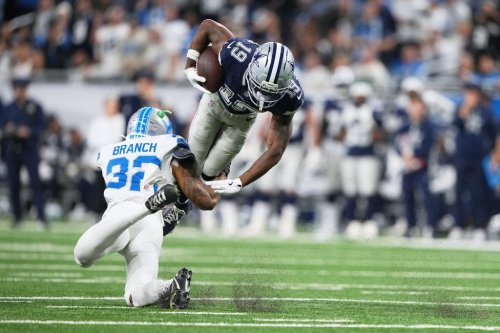 Dallas Cowboys wide receiver Ryan Flournoy (19) takes a hit from Detroit Lions safety Brian Branch (32) during the second half of an NFL football game Thursday, Dec. 4, 2025, in Detroit. (AP Photo/Ryan Sun)
