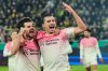 Leverkusen's Ibrahim Maza, right, celebrates with Leverkusen's Jonas Hofmann, left, after scoring the opening goal during the German Soccer Cup round of sixteen soccer match between Borussia Dortmund and Bayer 04 Leverkusen in Dortmund, Germany, Tuesday, Dec. 2, 2025. (AP Photo/Martin Meissner)
