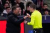 Atletico Madrid's head coach Diego Simeone speaks with referee François Letexier after receiving a yellow card during the Champions League opening phase soccer match between Atletico Madrid and Inter Milan, in Madrid, Spain, Wednesday, Nov. 26, 2025. (AP Photo/Manu Fernandez)