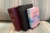 Three bibles sit on a couch Monday, Nov. 24, 2025, in Brooklyn, New York. (AP Photo/David Crary)