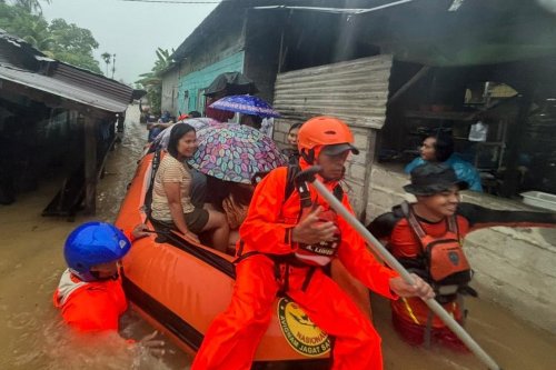 In this photo released by the Indonesian National Search and Rescue Agency (BASARNAS), rescuers on a rubber boat evacuate residents from their flooded home in North Sumatra province, Indonesia Tuesday, Nov. 25, 2025. (BASARNAS via AP)