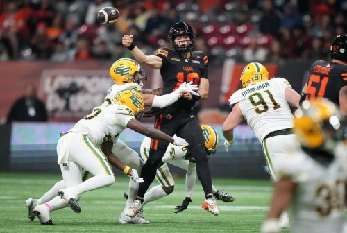 B.C. Lions quarterback Nathan Rourke, back centre, is hit by Edmonton Elks' Noah Taylor, back left, as his pass is intercepted during the second half of a CFL football game, in Vancouver, on Friday, October 17, 2025. THE CANADIAN PRESS/Darryl Dyck