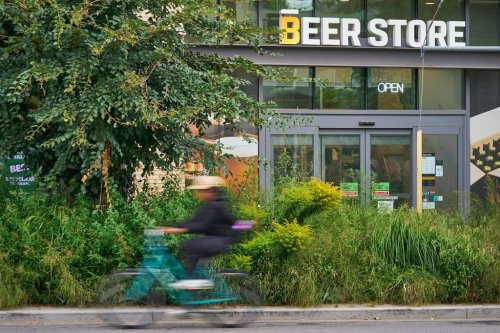 Cyclists pass a now-closed Beer Store in Toronto’s east end, on Tuesday, August 19, 2025. THE CANADIAN PRESS/Sammy Kogan
