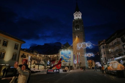 A couple takes a photo in front of the Milan Cortina Winter Olympics countdown clock, in Cortina D'Ampezzo, Friday, Nov. 21, 2025. (AP Photo/Andrew Medichini)
