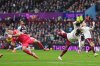 Aston Villa's goalkeeper Emiliano Martinez, left, makes a save ahead of Arsenal's Bukayo Saka during the English Premier League soccer match between Aston Villa and Arsenal in Birmingham, England, Saturday, Dec. 6, 2025. (AP Photo/Dave Shopland)
