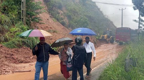 People walk past a section of a highway blocked by a landslide caused by heavy rain in Badulla, Sri Lanka, Thursday, Nov, 27, 2025. (AP Photo)