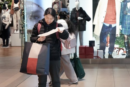 A shopper checks a till receipt in Toronto's Fairview Mall as outlets participate in Black Friday sales, Friday, Nov. 28, 2024. THE CANADIAN PRESS/Chris Young