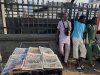 People stand near a display local newspapers on the street of Lagos with headlines on gunmen abducting schoolchildren and staff of the St. Mary's Catholic Primary and Secondary School in Papiri community in Nigeria, Saturday, Nov. 22, 2025. (AP Photo/Sunday Alamba )