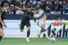 Los Angeles FC's Mark Delgado, left, and Vancouver Whitecaps' Thomas Muller vie for the ball during the second half of the MLS Western Conference semifinal playoff soccer match, in Vancouver, on Saturday, November 22, 2025. THE CANADIAN PRESS/Darryl Dyck