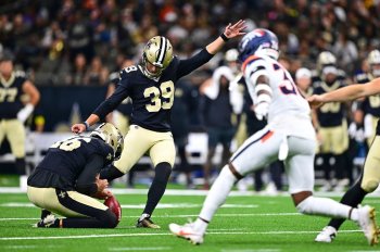 FILE - New Orleans Saints holder James Burnip, left, places the ball for place kicker Charlie Smyth to make a field goal as Denver Broncos special teams player Quinton Newsome comes in to defend in the second half of an NFL preseason football game Aug. 23, 2025, in New Orleans. (AP Photo/Ella Hall, File)