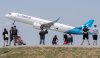 People look on as an Air Transat plane takes off at Trudeau  in Montreal, Sunday, June 11, 2023. THE CANADIAN PRESS/Graham Hughes