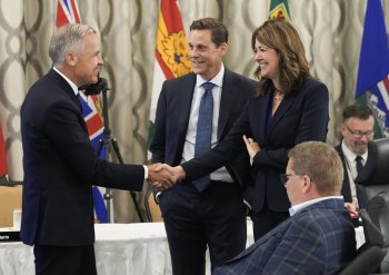 Prime Minister Mark Carney, left, greets Alberta Premier Danielle Smith during the 2025 summer meetings of Canada's premiers at Deerhurst Resort in Huntsville, Ont., on Tuesday, July 22, 2025. THE CANADIAN PRESS/Nathan Denette