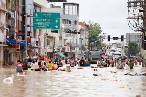 People wade through floodwaters in Songkhla province, southern Thailand, Thursday, Nov. 27, 2025. (AP Photo/Sarot Meksophawannakul)
