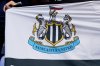 FILE - Newcastle's fans hold up their team's flag before an English Premier League soccer match at Selhurst Park in London, on Oct. 23, 2021. (AP Photo/Steve Luciano)