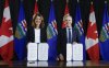 Prime Minister Mark Carney, right, signs an MOU with Alberta Premier Danielle Smith in Calgary on Thursday, Nov. 27, 2025. THE CANADIAN PRESS/Jeff McIntosh