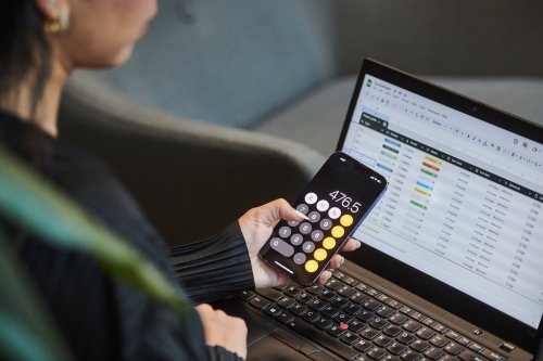 A person uses the calculator app on their phone and works on a spreadsheet in a photo illustration made in Toronto, on Monday, Sept. 22, 2025. THE CANADIAN PRESS/Sammy Kogan