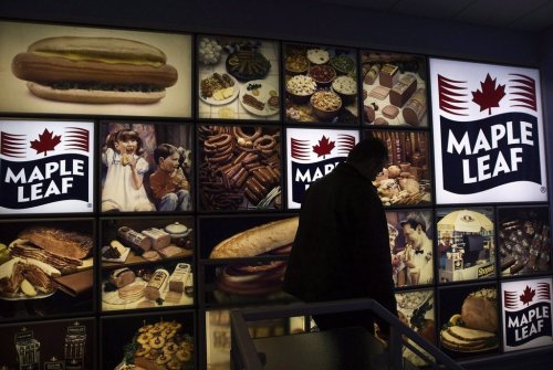 A Maple Leaf Foods employee walks past a Maple Leaf sign at the company's meat facility in Toronto on Monday, Dec. 15, 2008. THE CANADIAN PRESS/Nathan Denette