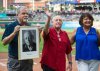 FILE - Former Akron Beacon Journal sports writer Sheldon Ocker, center, a 2018 Baseball Hall of Fame inductee, stands with cleveland.com sports reporter Paul Hoynes and his wife Stephanie as he is honored by the Cleveland Indians before a baseball game against the Baltimore Orioles in Cleveland, Friday, Aug. 17, 2018. (AP Photo/Phil Long, File)