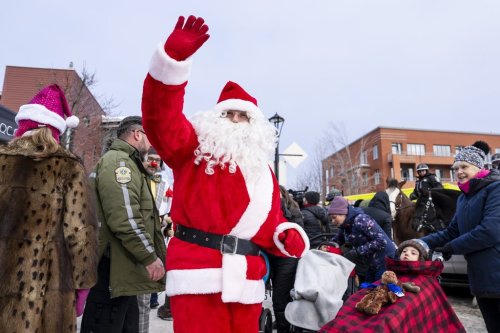 Santa Claus waves to children as they enjoy a Christmas parade in front of La Phare, a palliative care clinic for children in Montreal, on Monday, Dec. 15, 2025. THE CANADIAN PRESS/Christopher Katsarov