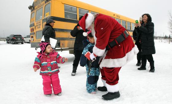 Kids get some goodbye hugs as Santa heads out to the helicopter after visiting the Black River Anishinabe School on the Little Black River First Nation during the Santa Express tour in December 2013. (Mike Deal / Free Press files)
