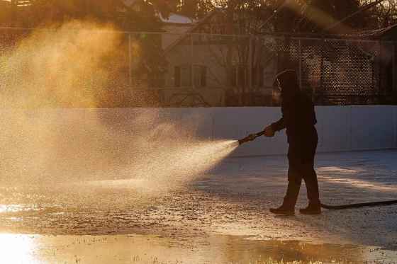 Icemaker Steve Smith sprays water on one of the rinks at R. A. Steen Community Centre early Wednesday morning. A small crew from Hinterland Nature, a nature worker co-op, has started to flood the ice rinks at a number of community centres in Winnipeg with the hope that they will be ready for skating by this weekend.