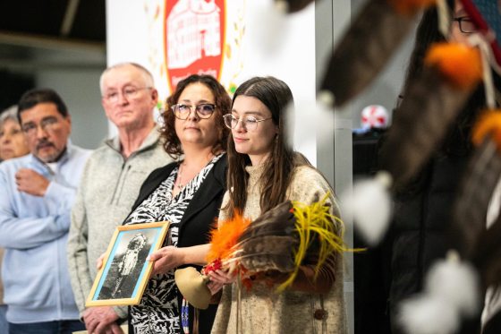 Fort la Reine Museum representative Caitlin Post carries the headdress in the grand entrance procession during the repatriation ceremony. (Mikaela MacKenzie / Free Press)