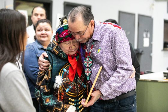 Maxine Walker-Merrick (left) and Randy Merrick embrace after the headdress repatriation ceremony. (Mikaela MacKenzie / Free Press)