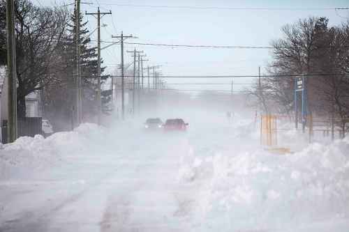 MIKAELA MACKENZIE / FREE PRESS

Trucks drive down Silver Avenue, west of Ferry Road, as snow blows across the streets on Thursday, Dec. 18, 2025.