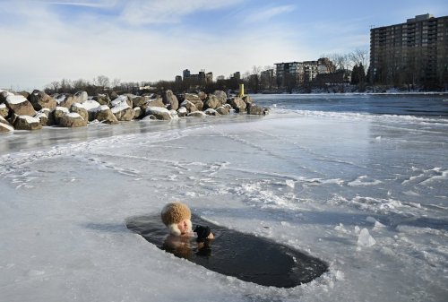 Mark Nikiforov sits in the St. Lawrence River during a polar plunge in Montreal, Wednesday, Dec. 31, 2025. THE CANADIAN PRESS/Graham Hughes