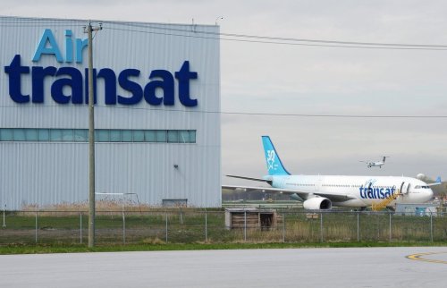 An Air Transat plane is seen as an Air Canada plane lands at Pierre Elliott Trudeau International Airport in Montreal on Thursday, May 16, 2019. THE CANADIAN PRESS/Ryan Remiorz